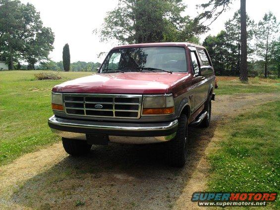Red and gray Ford Bronco parked on a gravel driveway