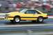 1992 Ford Mustang - A yellow 1987 Ford Mustang is captured in motion on a drag strip, its racing modifications.