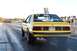 1992 Ford Mustang - Yellow 1992 Ford Mustang drag car performing a burnout on the starting line of a drag strip.