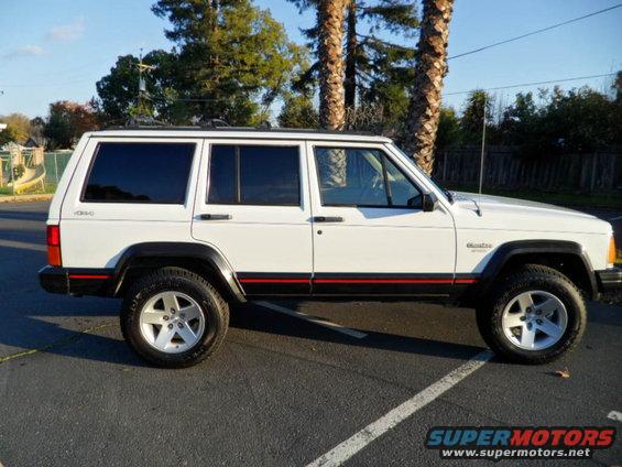 White 1994 Jeep Cherokee side profile with black fender flares and red stripe
