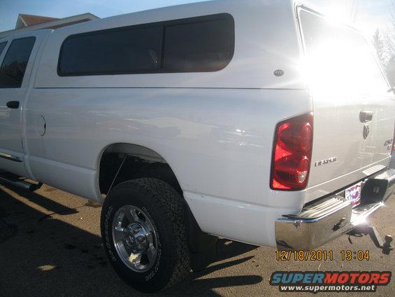 Rear quarter view of a white Dodge Ram pickup truck with a camper shell. Date stamp 12/18/2011