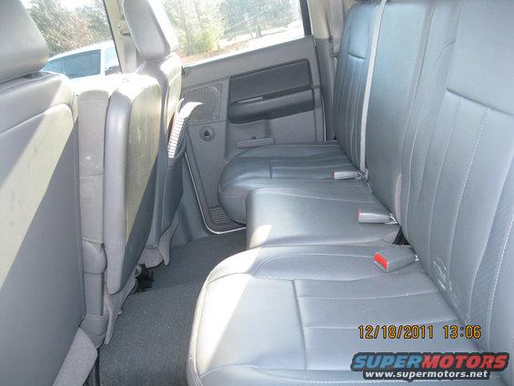 Rear seats and interior of a pickup truck. Watermark reads SUPERMOTORS