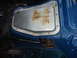 1987 Ford F-150 - Interior view of a blue truck cab showing a rusted metal panel and exposed floor area.