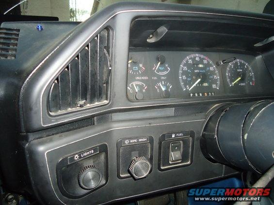 1987 Ford F-150 dashboard with gauges, vents, and control knobs. Speedometer reads 0