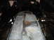 1987 Ford F-150 - The underside of a vehicle shows a large, metallic fuel tank with some rust present.