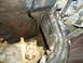 1987 Ford F-150 - Close-up view of the undercarriage of a vehicle, revealing mechanical components and signs of wear.