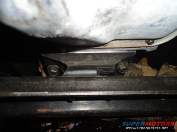 Underside view of a vehicle's frame and some mechanical components, possibly a transmission mount