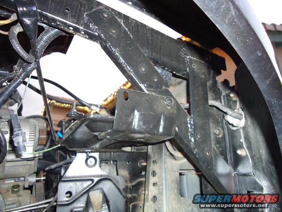 Engine bay structure with visible alternator and wiring