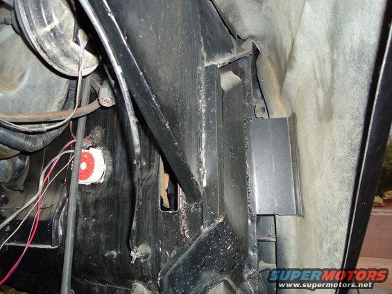 Close-up of wiring and metal brackets in a vehicle's engine bay