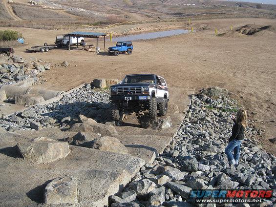 Two-tone Ford Bronco on a rocky obstacle course, front view