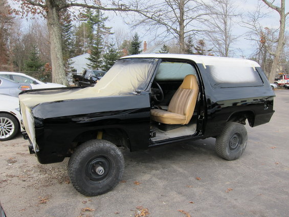 Black Dodge Ramcharger with tan interior, hood and roof taped off for painting