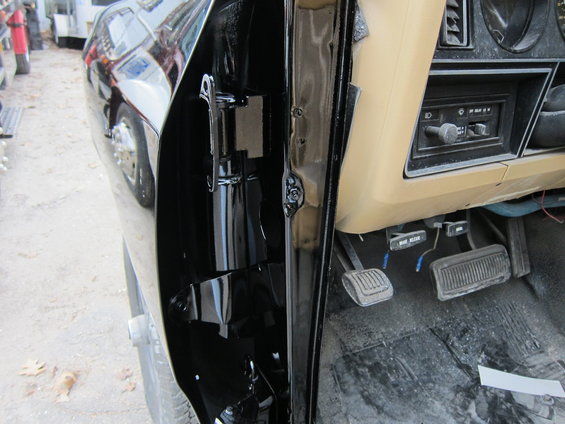 Black truck door jamb and tan dashboard with radio and pedals visible