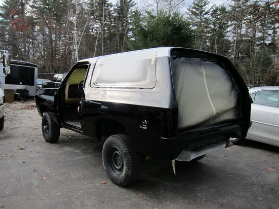 Black SUV with white roof, rear quarter view, undergoing paintwork