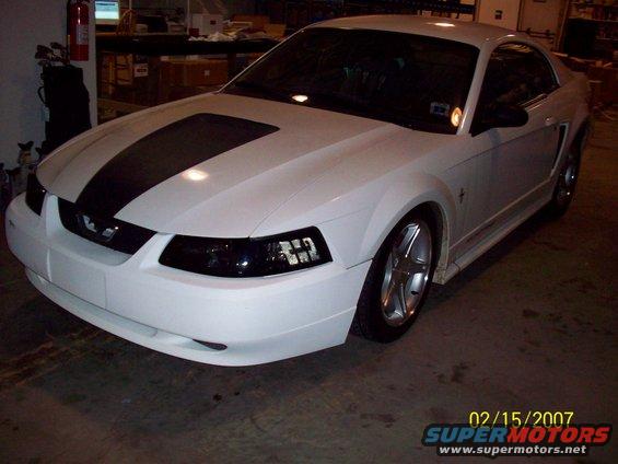 White 2000 Ford Mustang with black racing stripes, 3/4 front view