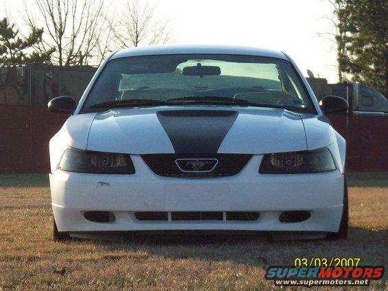 Front view of a white 2000 Ford Mustang with a black stripe on the hood
