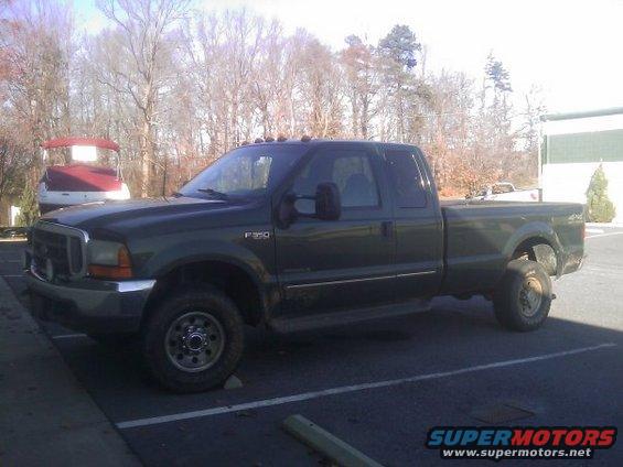 Dark green Ford F-350 pickup truck parked in a lot, side view