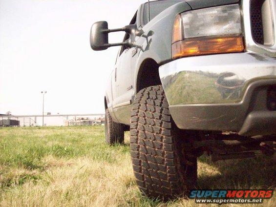 Dark green 2000 Ford F-350 front tire and quarter panel