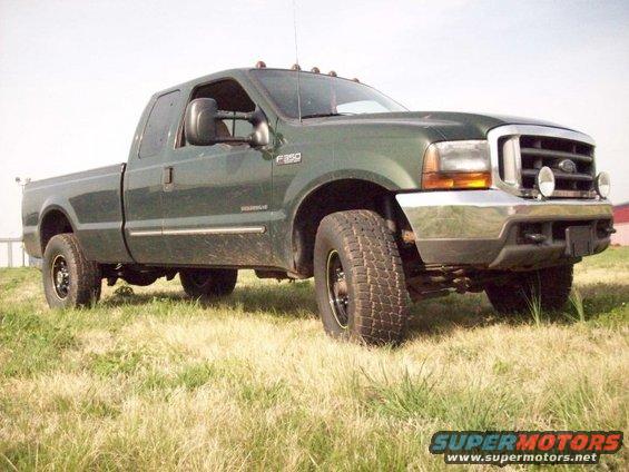 Green 2000 Ford F-350 pickup truck parked in a grassy field
