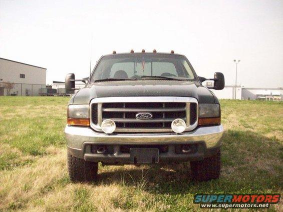 Front view of a dark green 2000 Ford F-350 truck with chrome grille and bumper