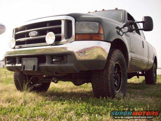 Dark green 2000 Ford F-350 front 3/4 view with chrome grille and large mirrors