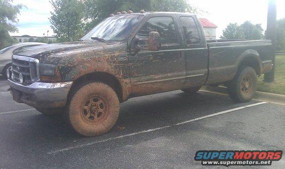 Mud-covered 2000 Ford F-350 pickup truck parked in a lot