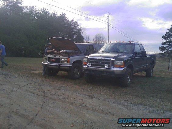2000 Ford F-350 parked next to a GMC pickup with hood open