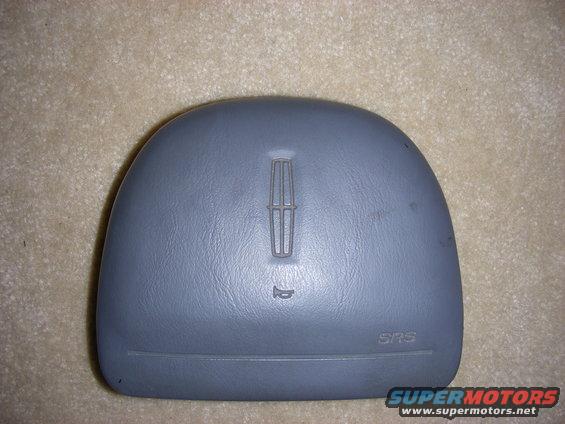 Gray airbag cover with Lincoln logo and horn symbol