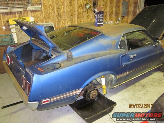 1969 Ford Mustang with trunk and hood open, rear wheel removed