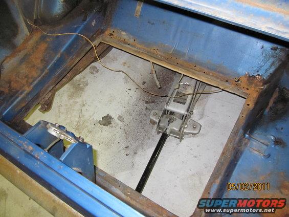 Blue car interior showing rust and a floor jack, viewed from above
