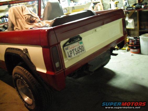 Rear view of a red and white pickup truck with a California license plate