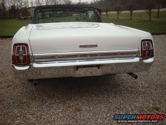 White 1967 Ford Galaxie convertible rear view, chrome bumper, dual exhaust pipes, gravel lot
