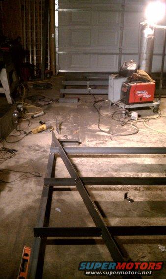 Metal frame construction in a garage with a welding machine and tools
