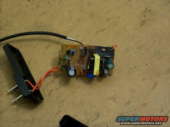Electronic circuit board with wires and a plug on a wooden surface