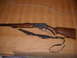 1952 Matchless G80 - A lever-action rifle with a wooden stock and a black sling is displayed on a cardboard surface.