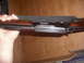 1952 Matchless G80 - Close-up view of a firearm's receiver and wooden stock, held in a hand.