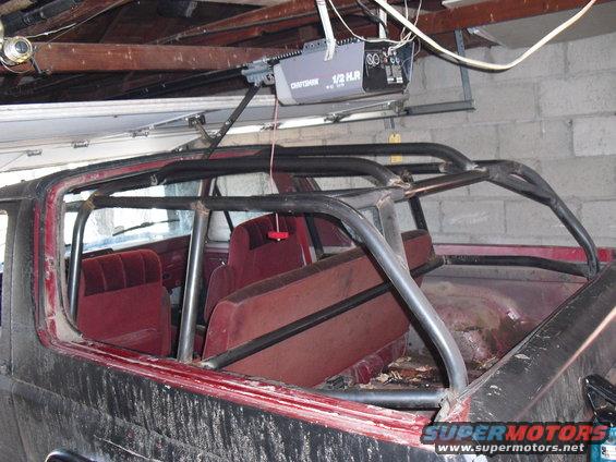 1986 Ford Bronco interior with roll cage and red seats