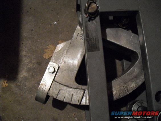 Close-up of a metal angle finder tool with markings and a label