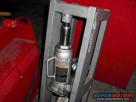 Hydraulic press frame with a Pro-Lift 4-ton bottle jack attached. Red toolbox visible to the left