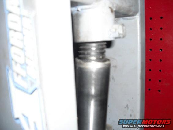 Close-up of a jack screw mechanism with visible threads and a metal shaft