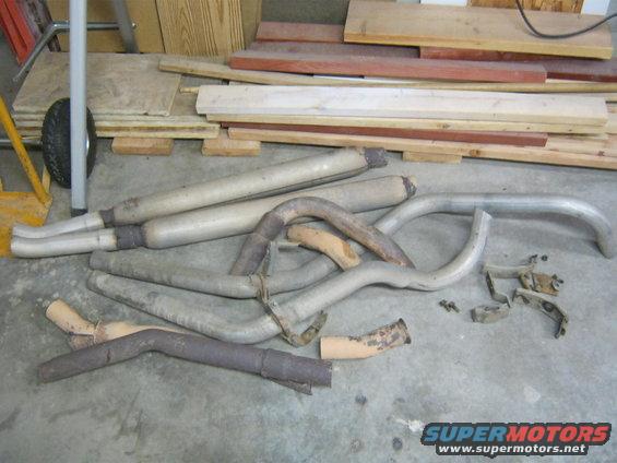 Exhaust pipes and mufflers laid out on a concrete floor