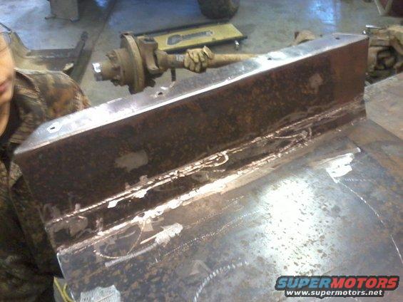 Gas tank skid plate with visible welds and a hub assembly