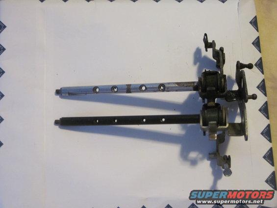 Two metal shafts with holes and mechanical linkages, likely steering column components