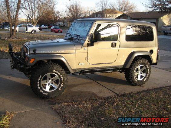 Jeep Wrangler Rubicon parked on driveway. Has aftermarket bumper and side steps