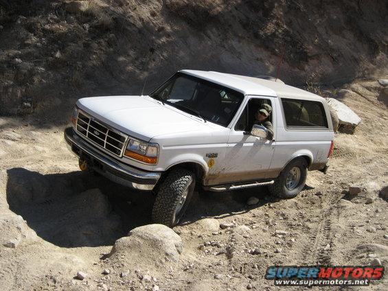 White 1996 Ford Bronco navigating a rough, rocky off-road trail