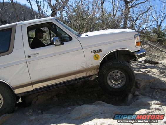 White 1996 Ford Bronco on rocky terrain, side view