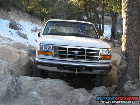 White Ford Bronco navigating rocky terrain, front view