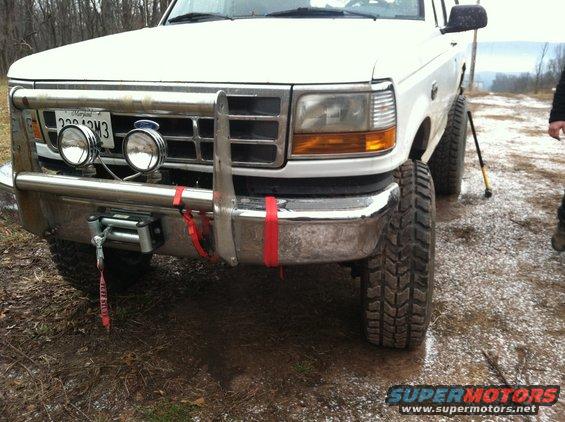White pickup truck front end with winch and auxiliary lights. Maryland license plate visible