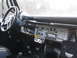 1967 Ford Mustang - The interior of a classic vehicle shows a dashboard with an aftermarket radio and auxiliary gauges.