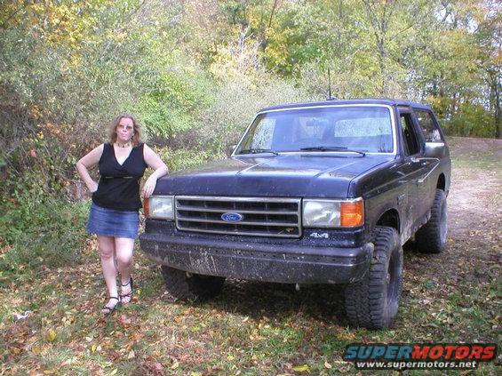 1989 Ford Bronco front 3/4 view with a woman standing beside it