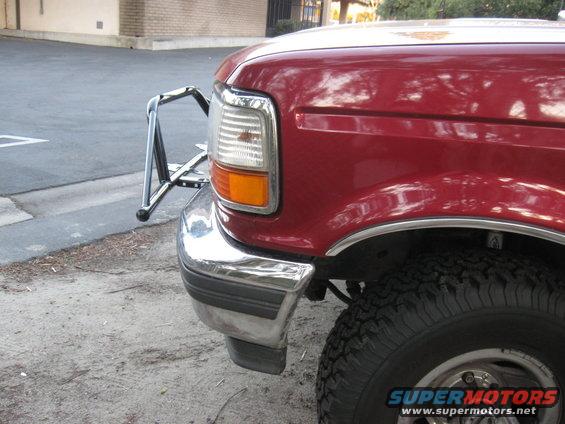 Front corner of a red 1995 Ford F-150 with a chrome brush guard and chrome bumper